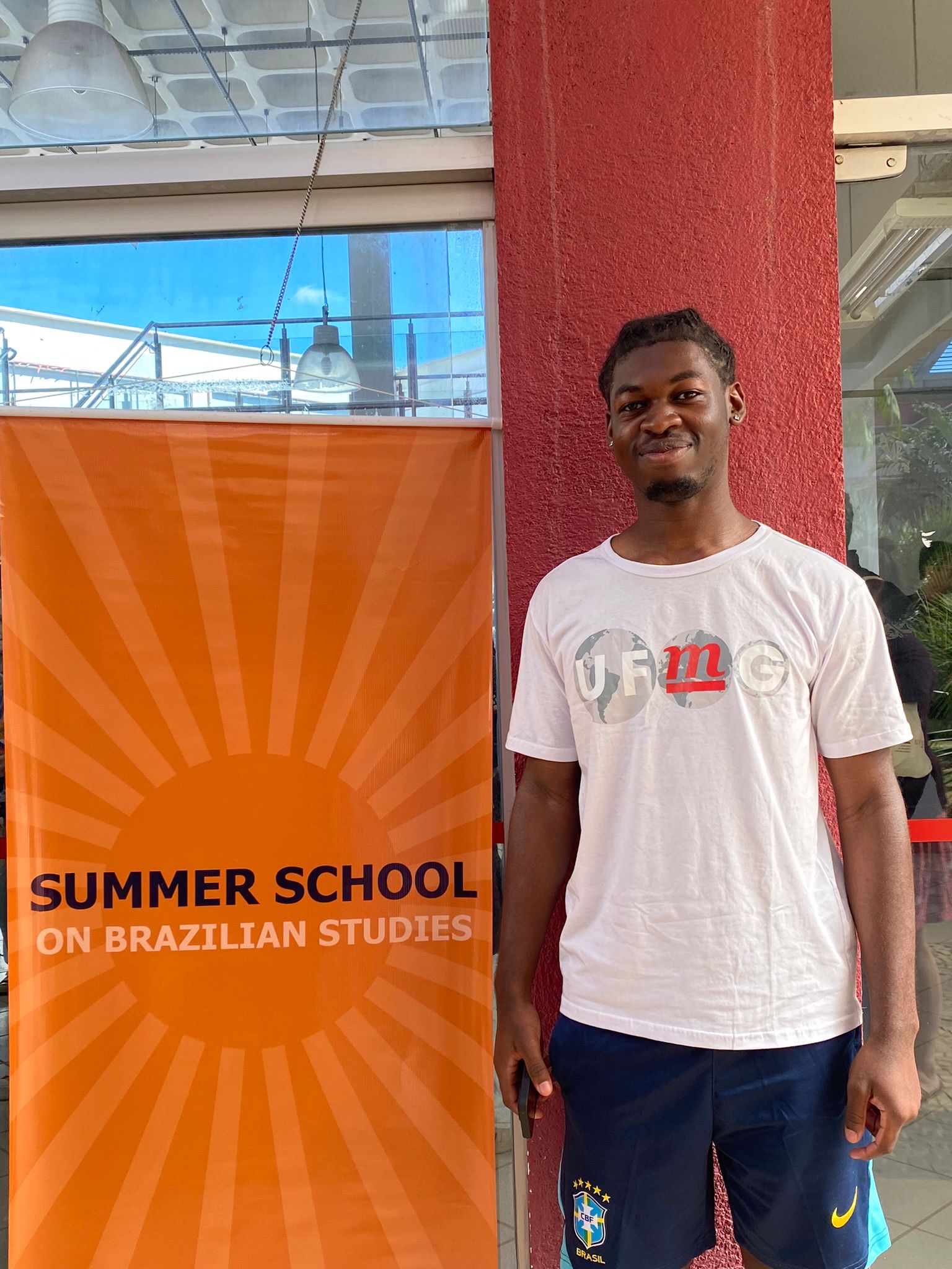 GSD student Kieran smiles at camera in front of Summer School sign