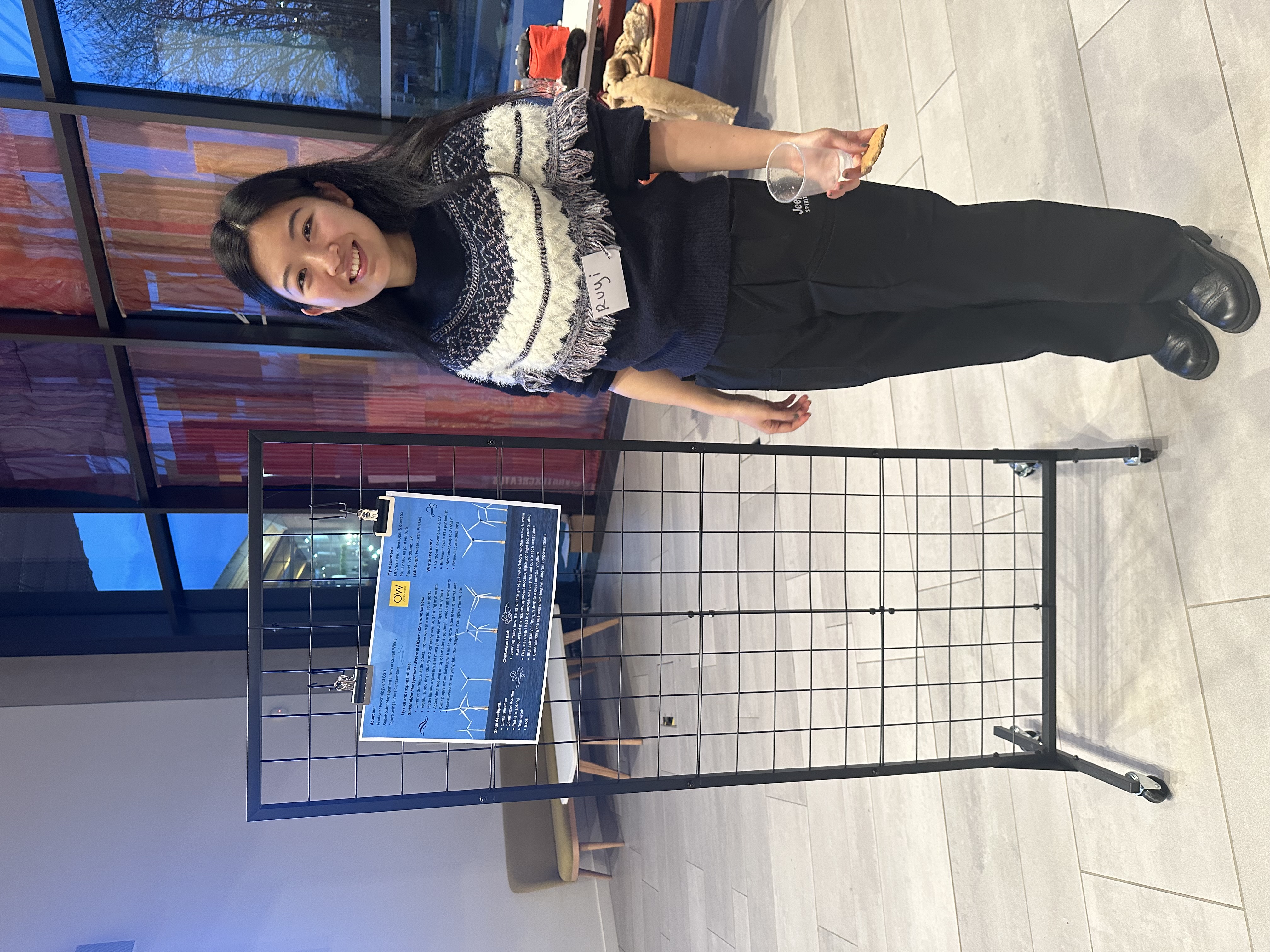 Ruyi stands in front of her presentation at the Work Placement Fair 2025