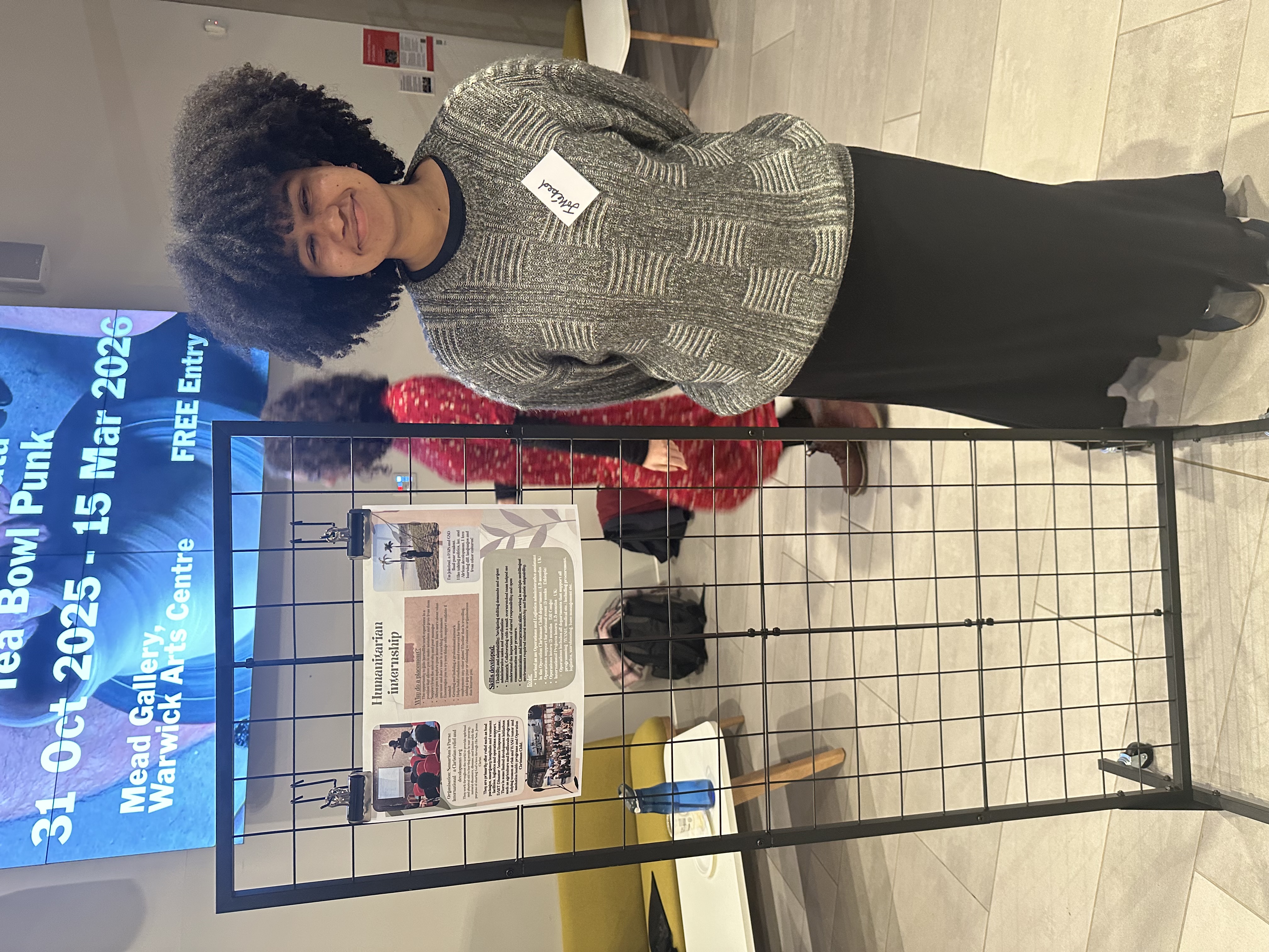 Jokebed stands in front of presentation at Work Placement Fair 2025