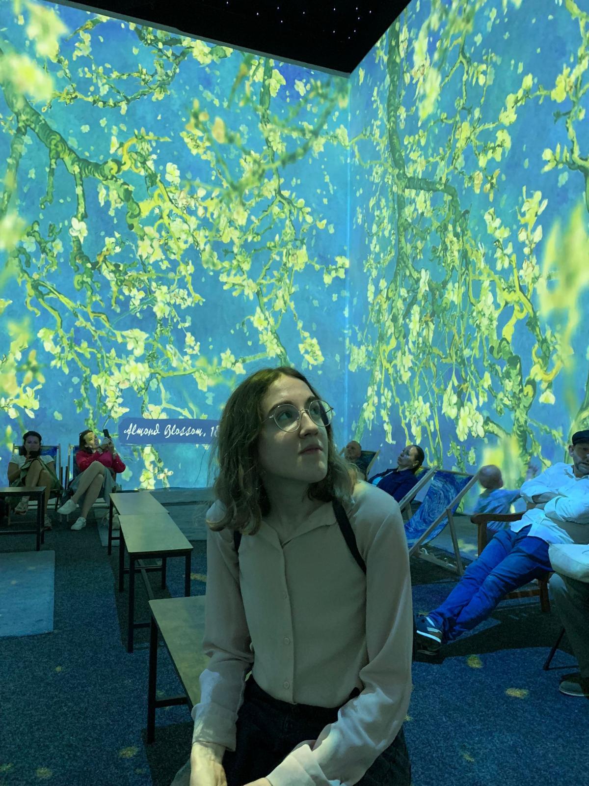 Woman sat in a museum looking up contemplatively