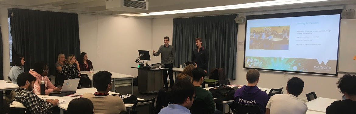Luke Netherclift, a GSD student, standing at the front of the room delivering a speech to students about the World Innovation Challenge