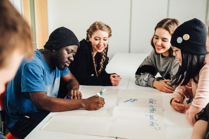 students writing on paper in group work exercise