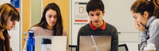 Students on laptops working together in a group setting