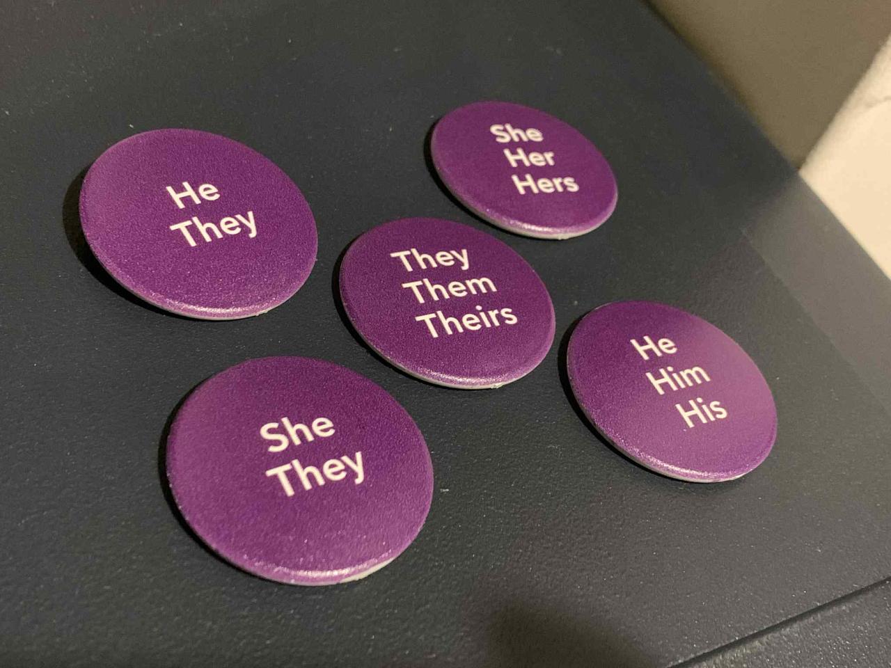 Image of the five pronoun badge variations available: he, she, they, he/they, and she/they