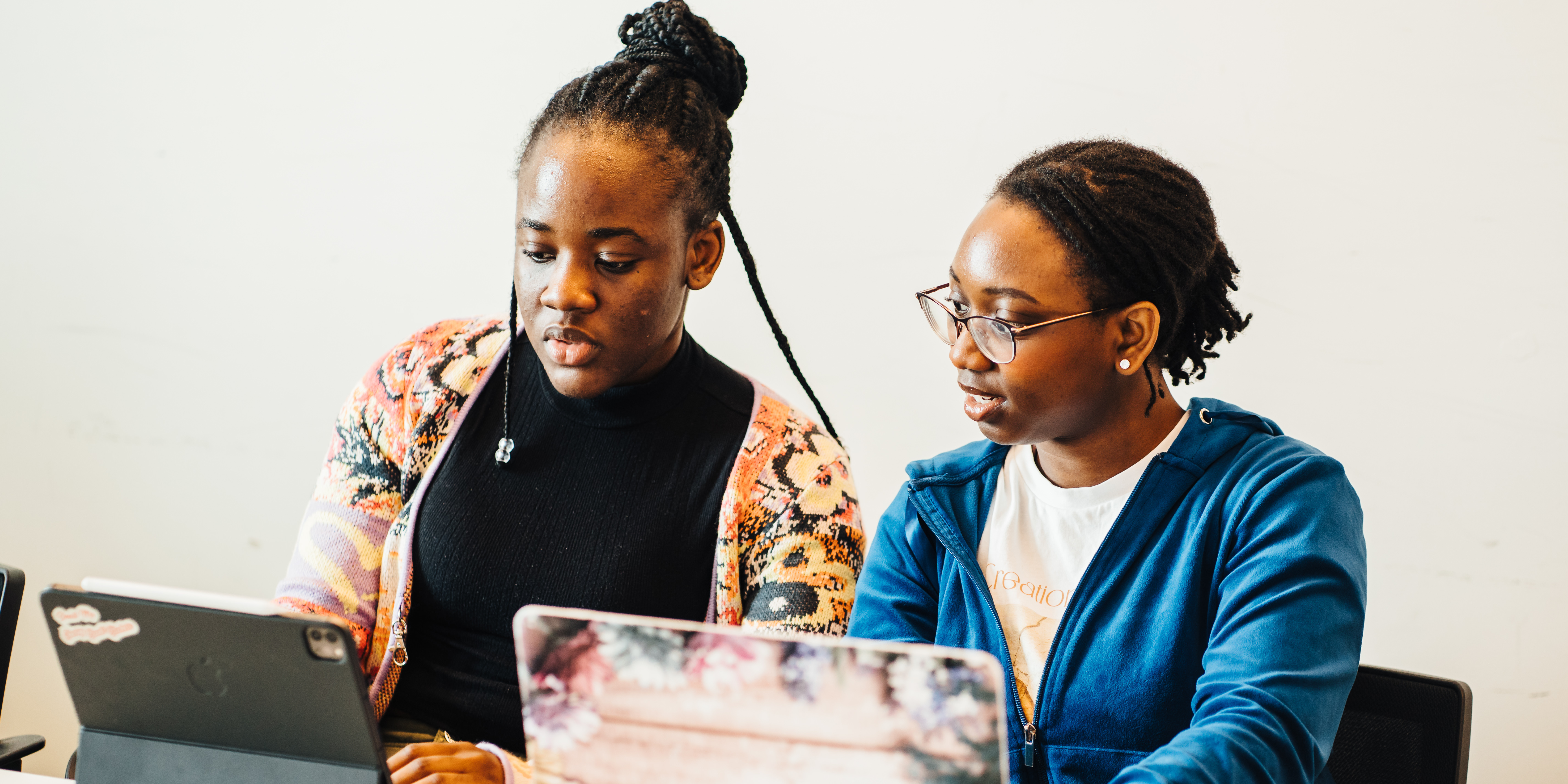 two students working on laptops