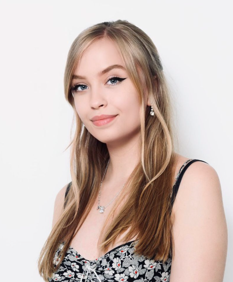 Grace Fisher, a white woman with mid-length blonde hair, smiling at the camera.