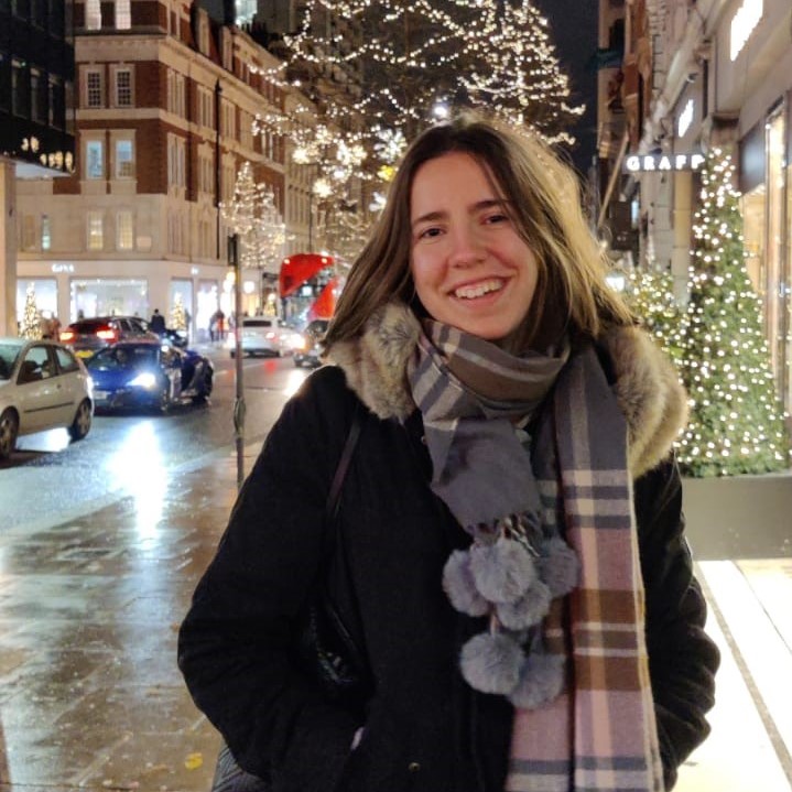Woman with scarf on a street with Christmas lights