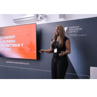 Image of women standing in fromt of a screen doing a presentation