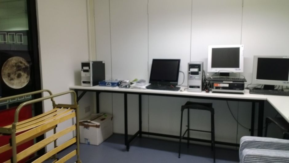 Figure 2: The lab set-up, with bed on the left ready to be positioned, necessary computers on the desk and the blue BIOPAC module in the middle of the picture.