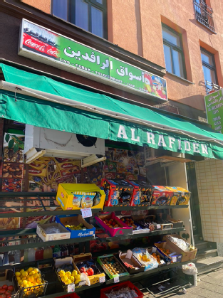 Tvåspråkig, bottom-up/inofficiell butiksskylt på arabiska överst