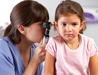 Doctor looking into young girl