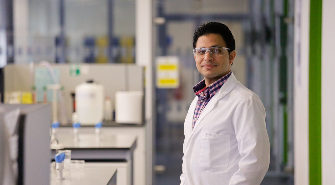 A research student in a lab coat in the lab