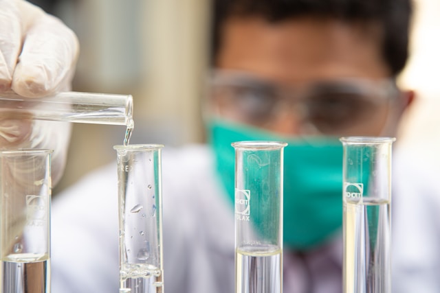 A man pouring a liquid into a test tube