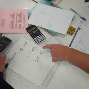 calculator and written calculations on a piece of paper