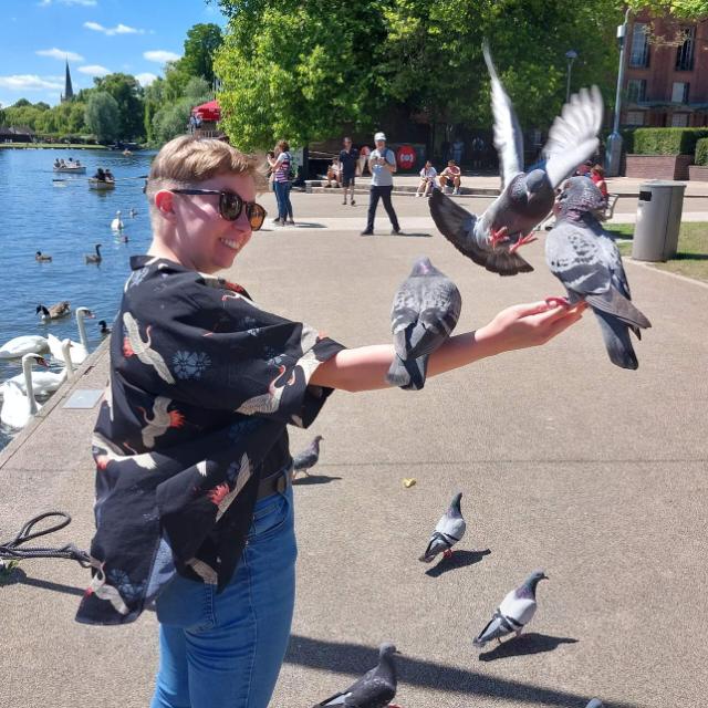 Photo of Laura Cairns, posing with pigeons on her arm