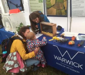 SLS student showing bee colony to mother and child at Kenilworth Show