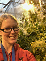 Jess in a glasshouse with brassica plants