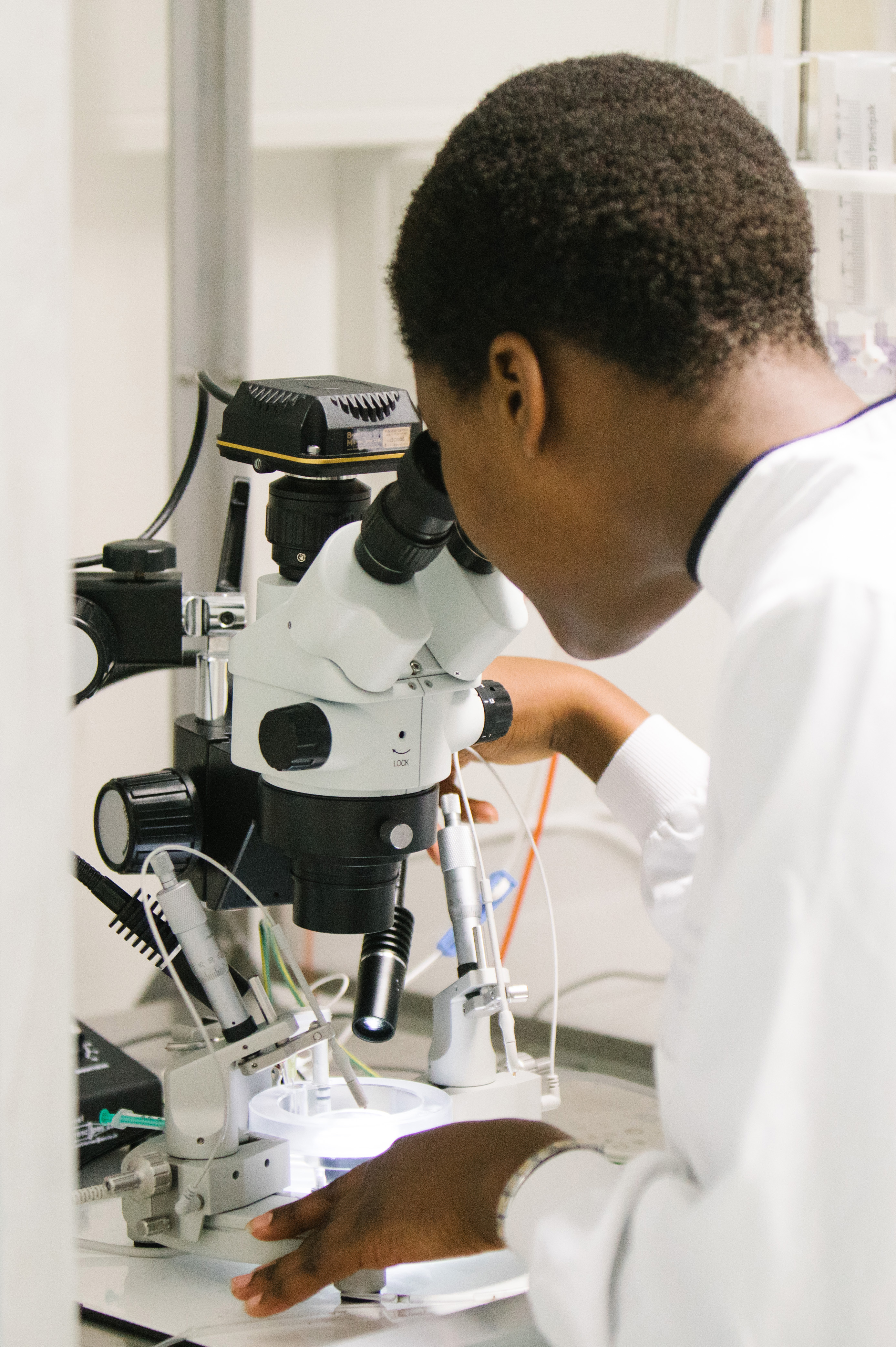 Female student looking down microscope