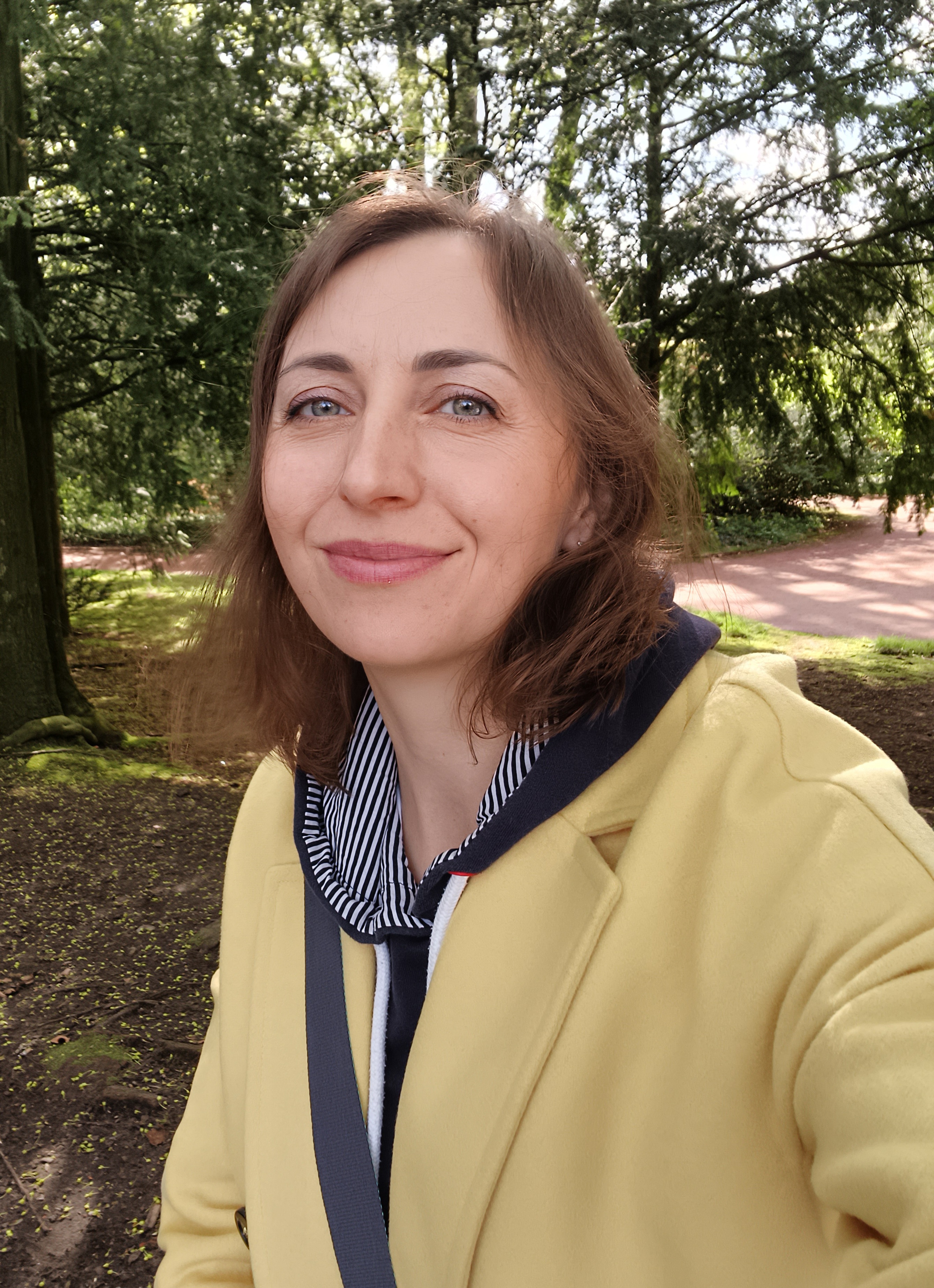 A woman in a yellow coat smiling