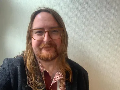 ginger haired man with beard and brown glasses
