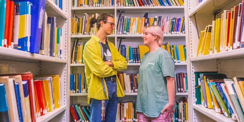 Two students chatting in a library