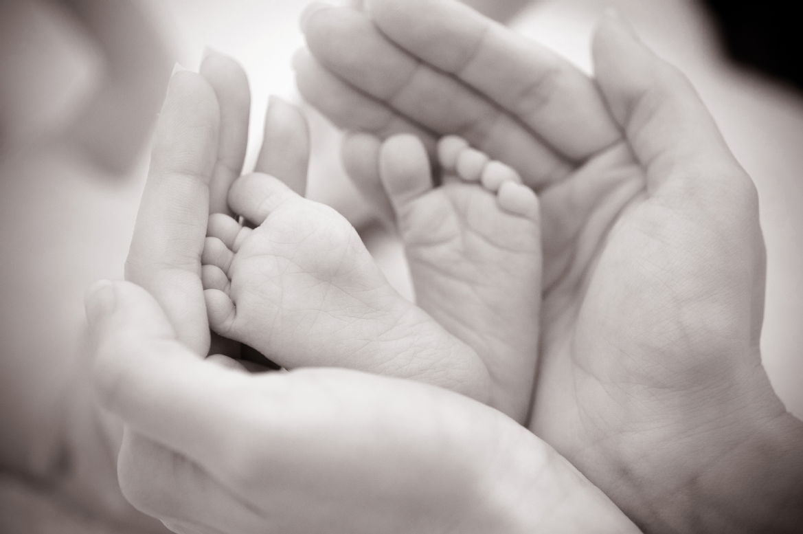 illustrative picture - adult hands holding baby's feet