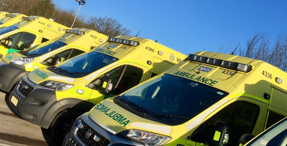 Photograph of the front of ambulances parked in depot