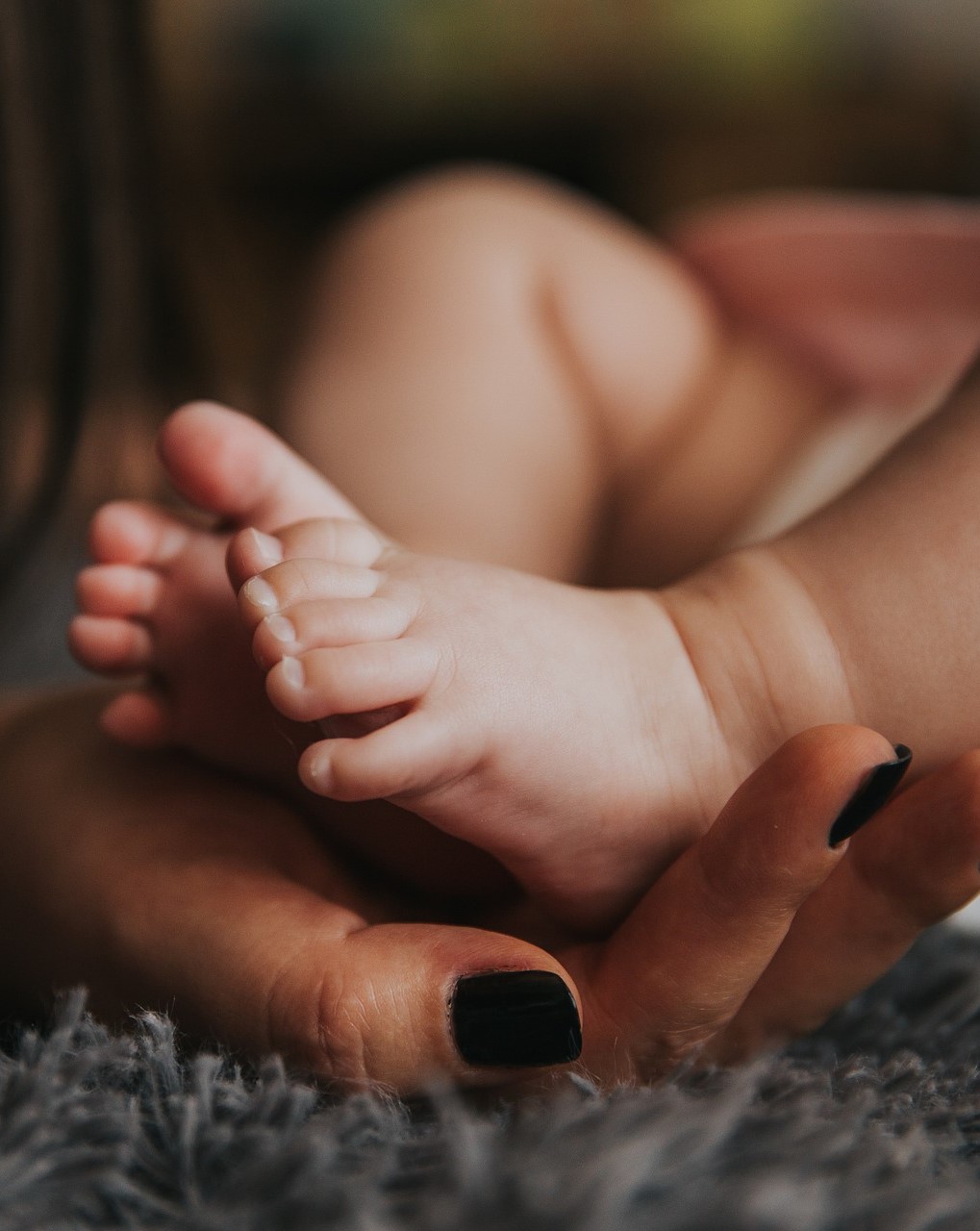mother holding baby feet