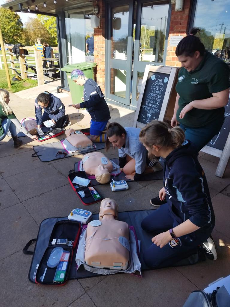 some people being taught to perform AED on a mannikin