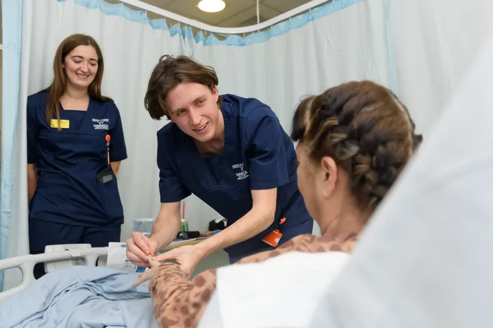 Students with patient in hospital setting