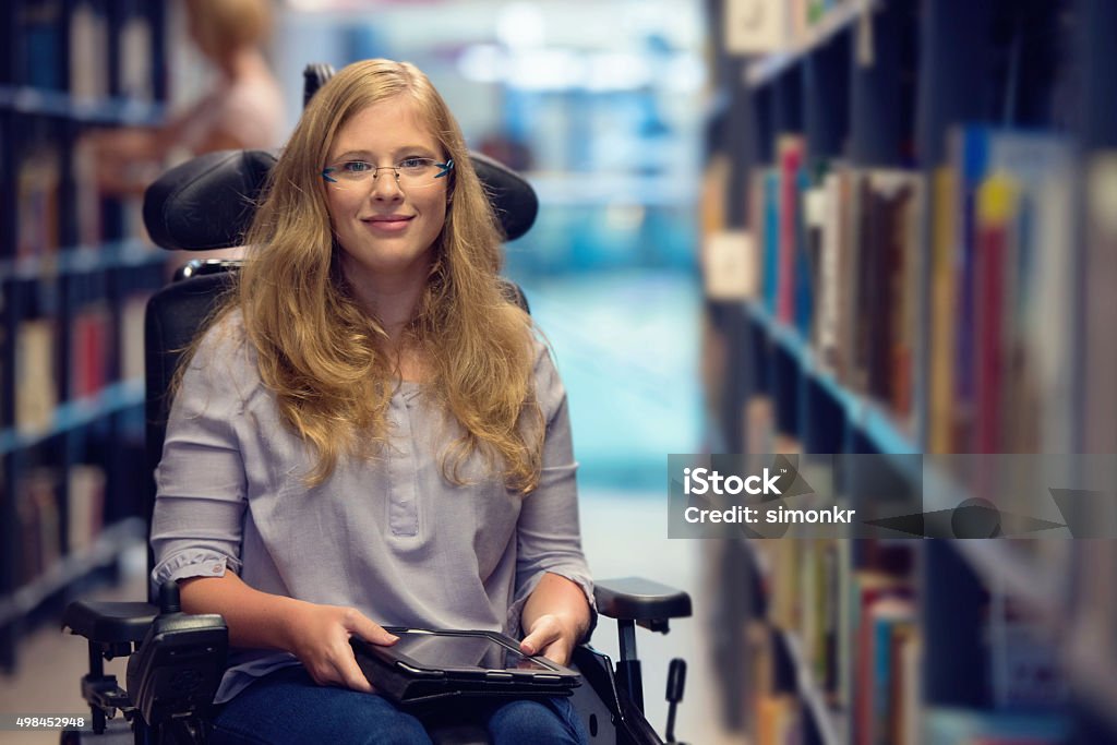 Female student in a wheelchair in a university library