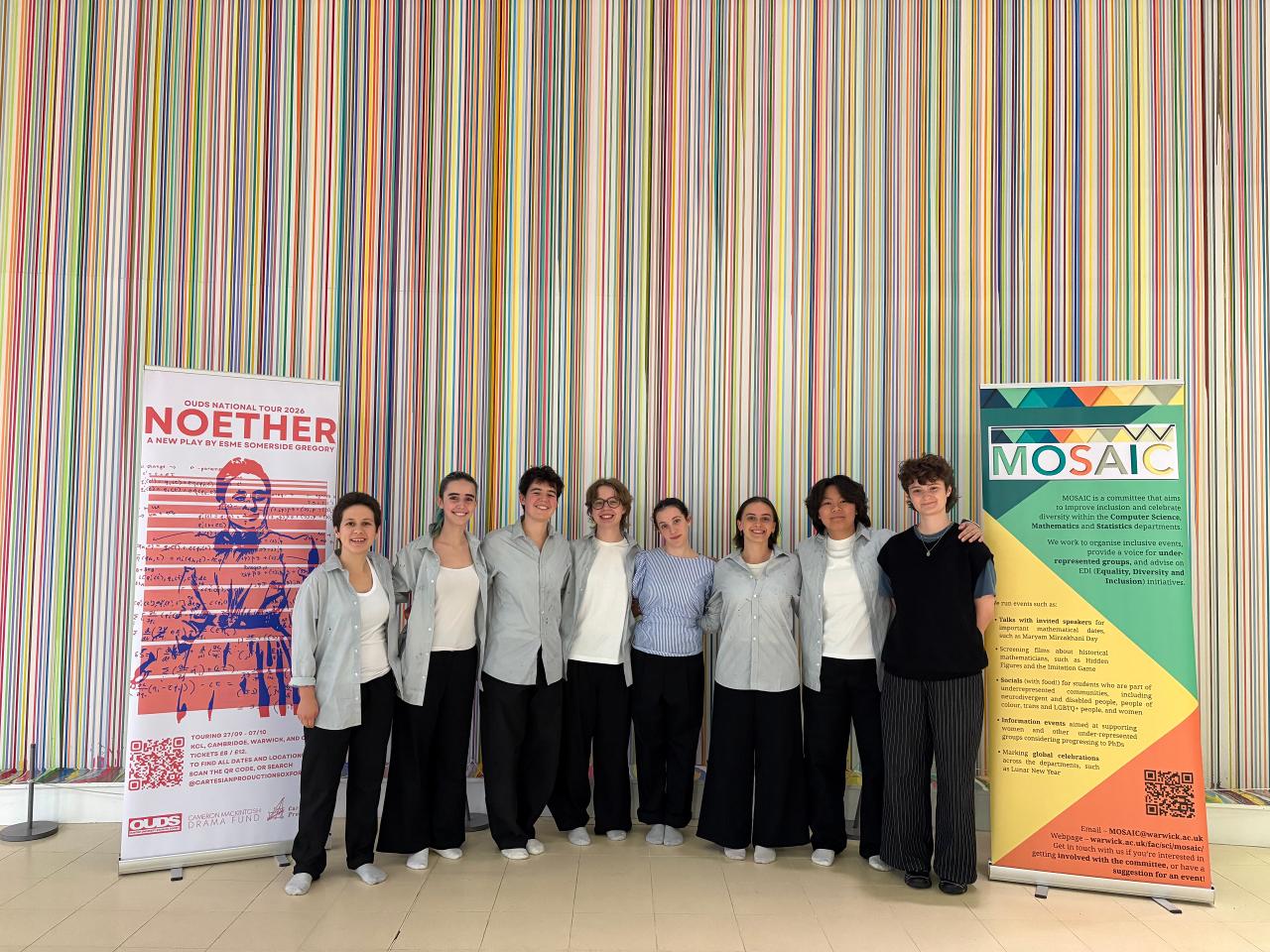 A photograph of the cast of Noether, with banners advertising Noether and MOSAIC.