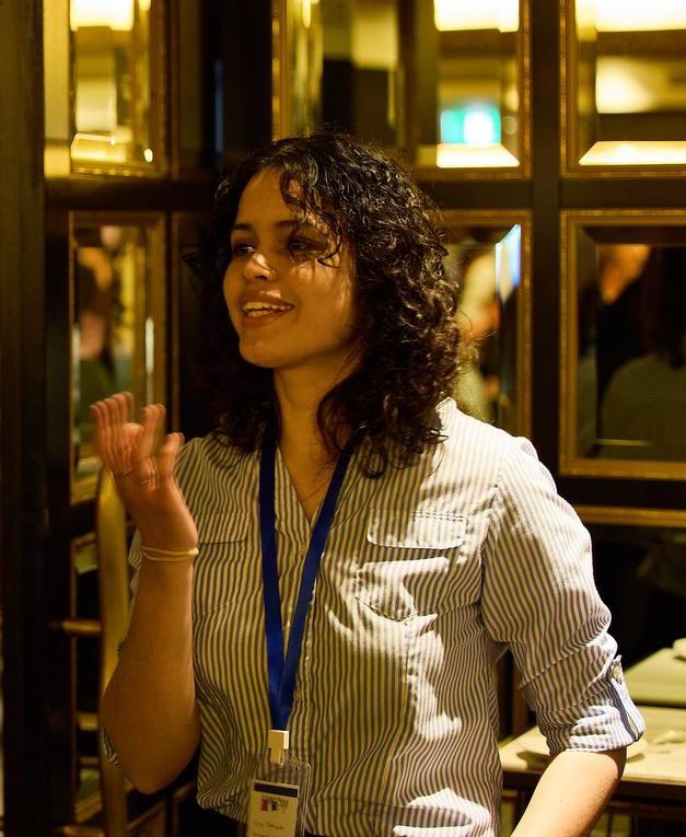 Photograph of Luisa captured while speaking to someone.