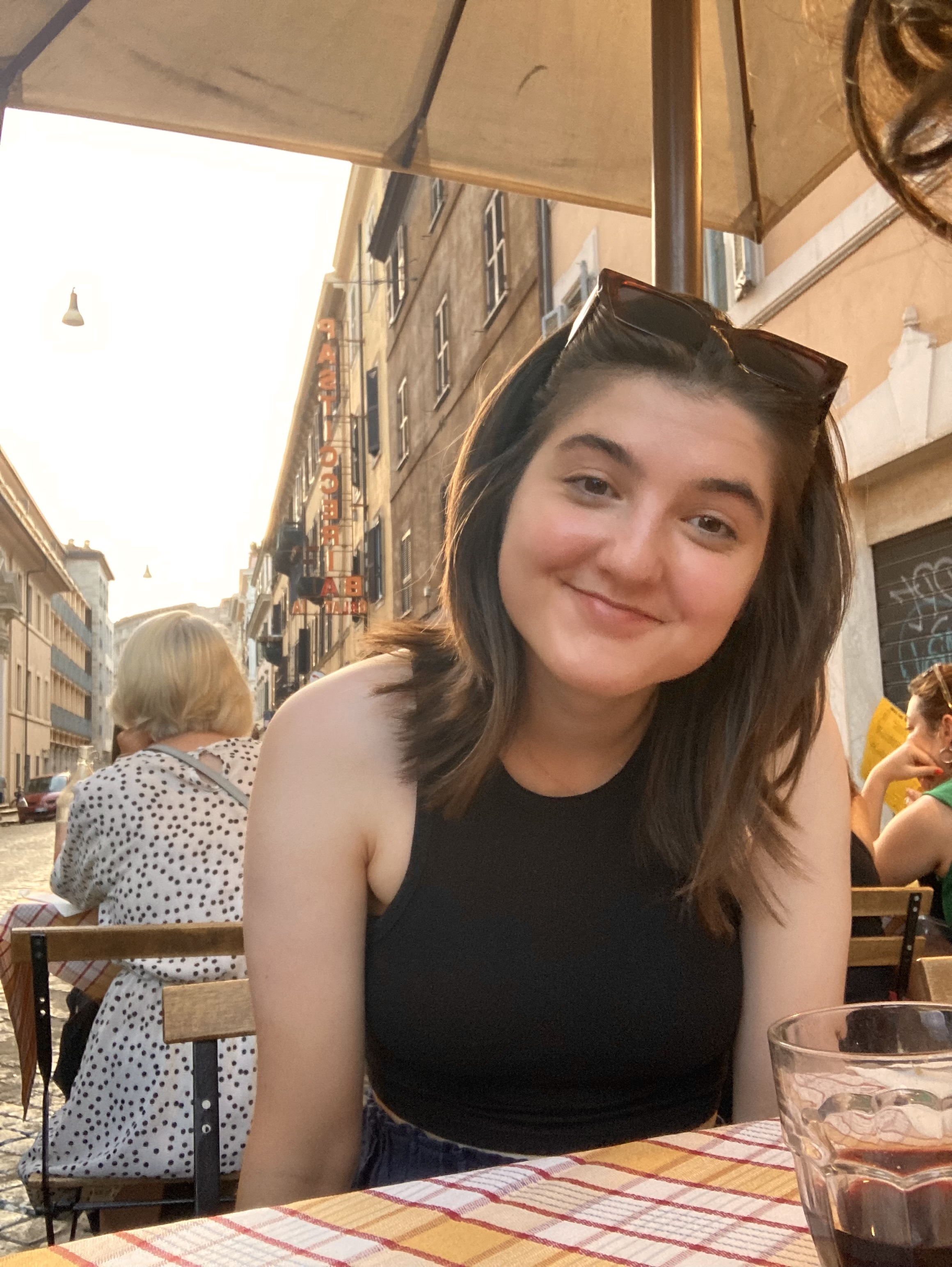 Photograph of Sasha, sitting on an outdoor table at a cafe.