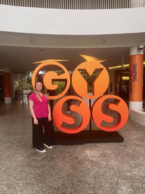 Elizabeth standing next to the GYSS conference sign