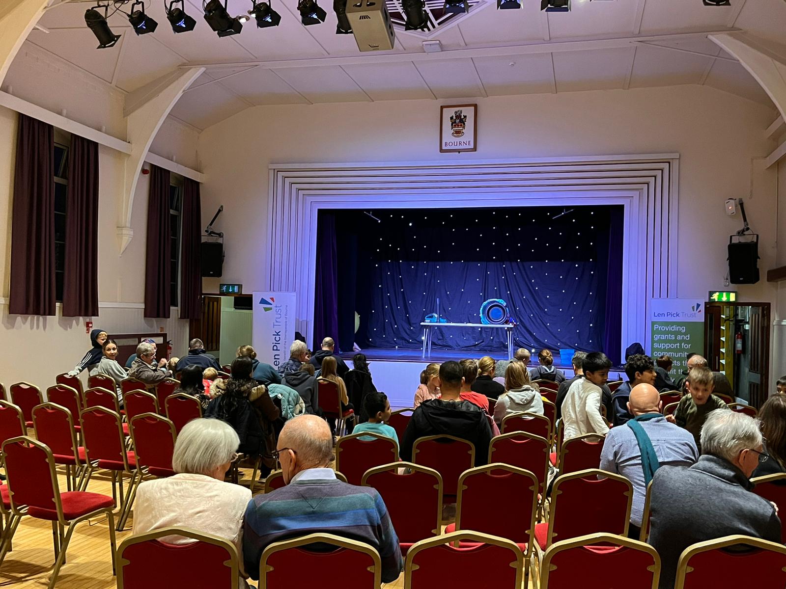 An audience looking at the stage in a village hall