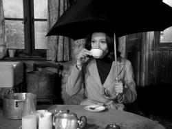 Emma Peel sips tea under an Umbrella in The Avengers: A surfeit of H2O