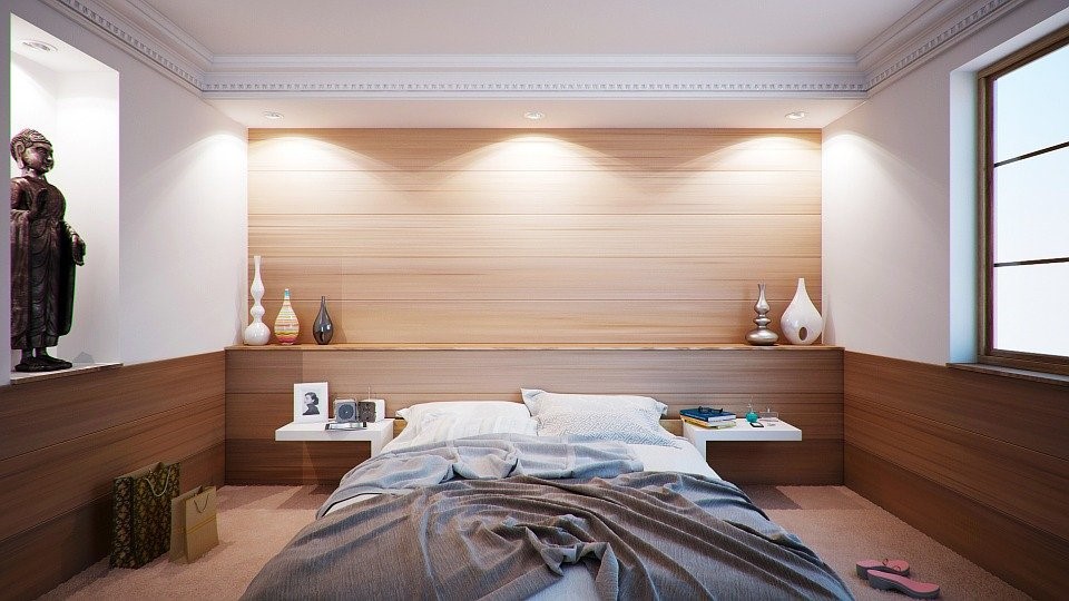 image of a tranquil, minimalist bedroom with slept-in covers.