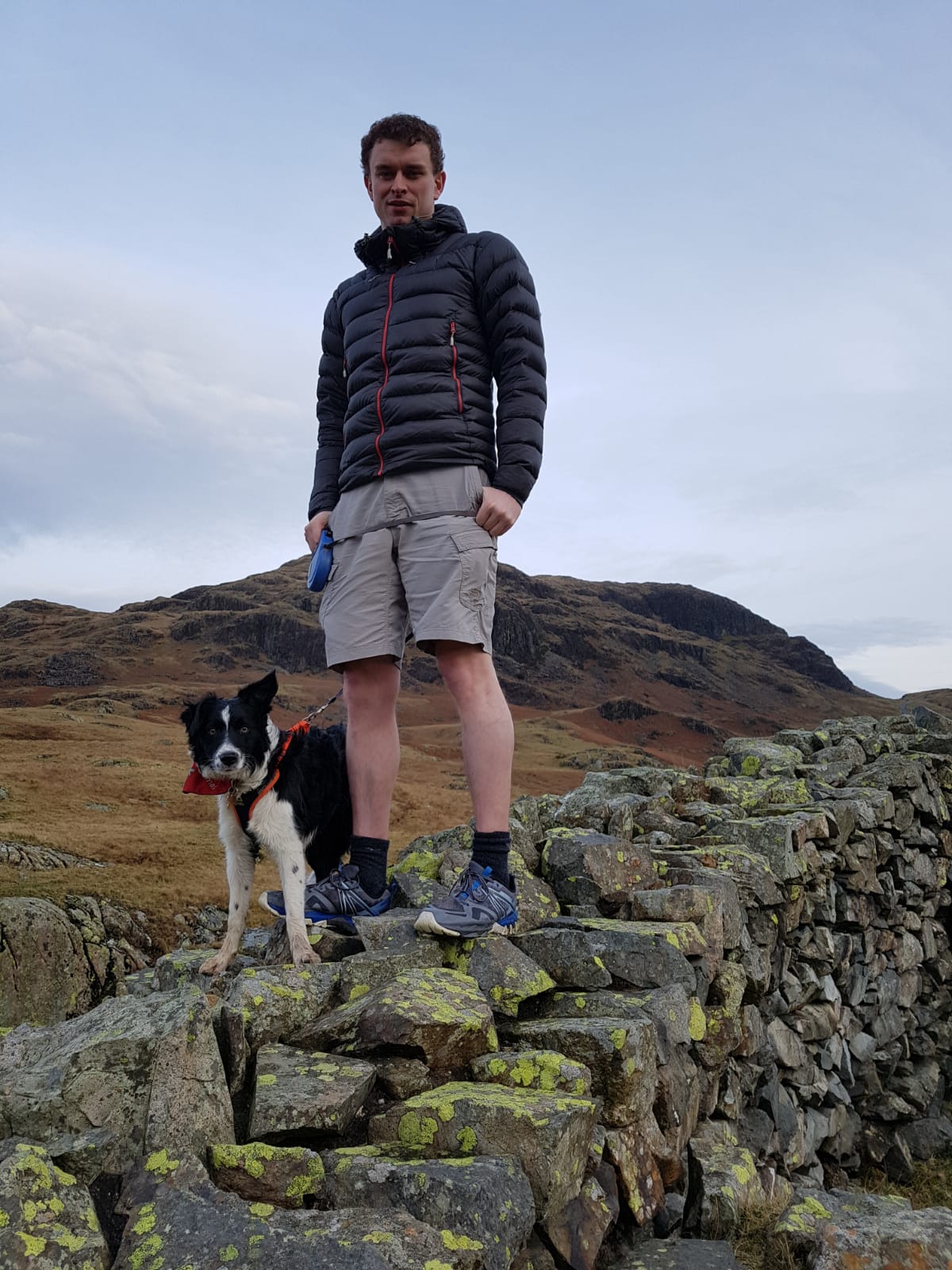 Nicholas Tawn standing on a wall with his dog.