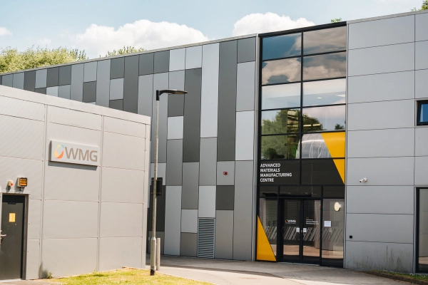 Exterior of the Advanced Materials Manufacturing Centre, complete with a grey panelled façade, large glass entrance, and WMG signage