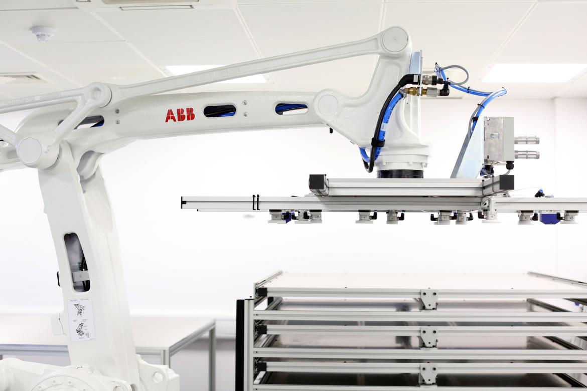a picture of a robot arm moving plates of composite materials