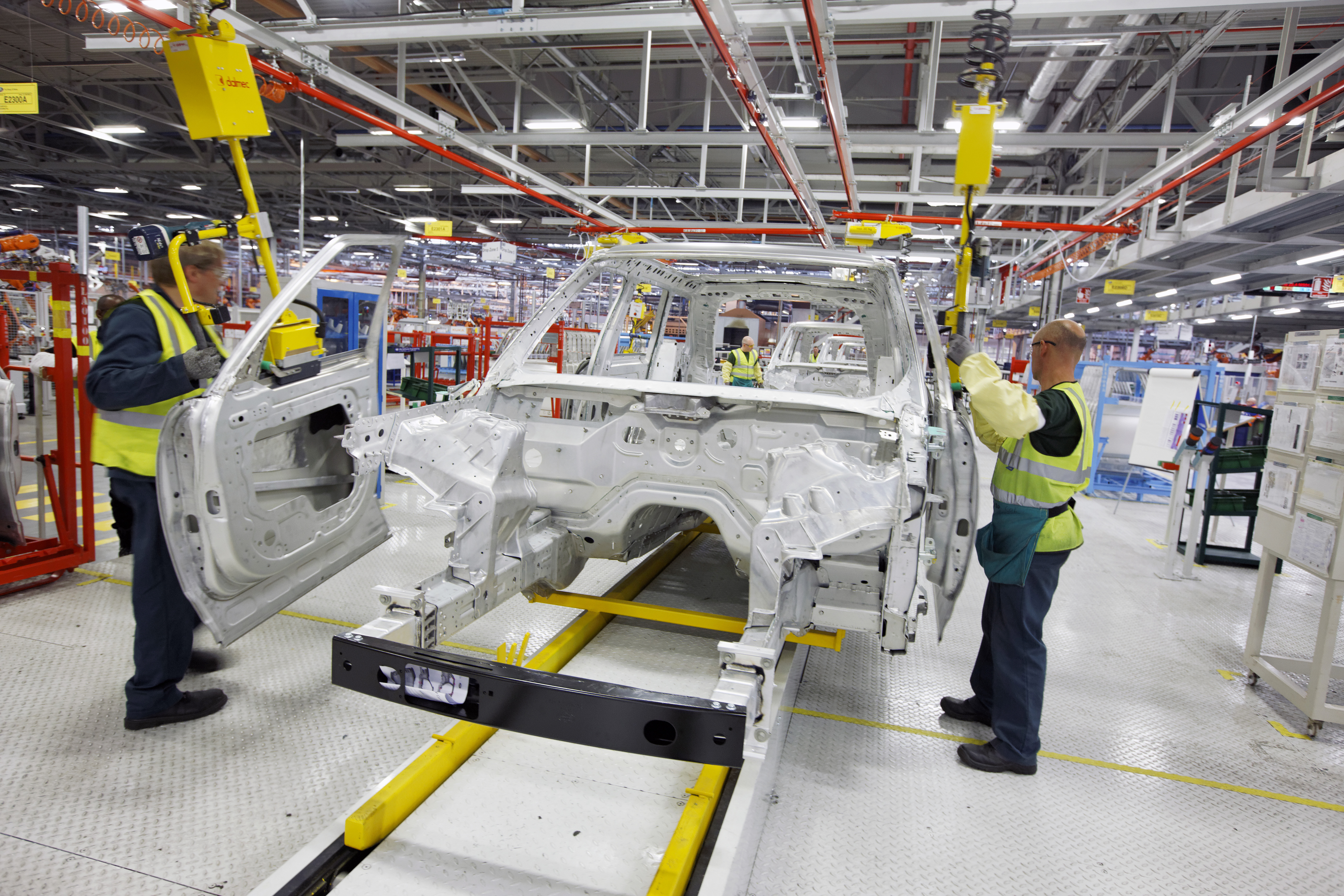 Two people assembling a car.