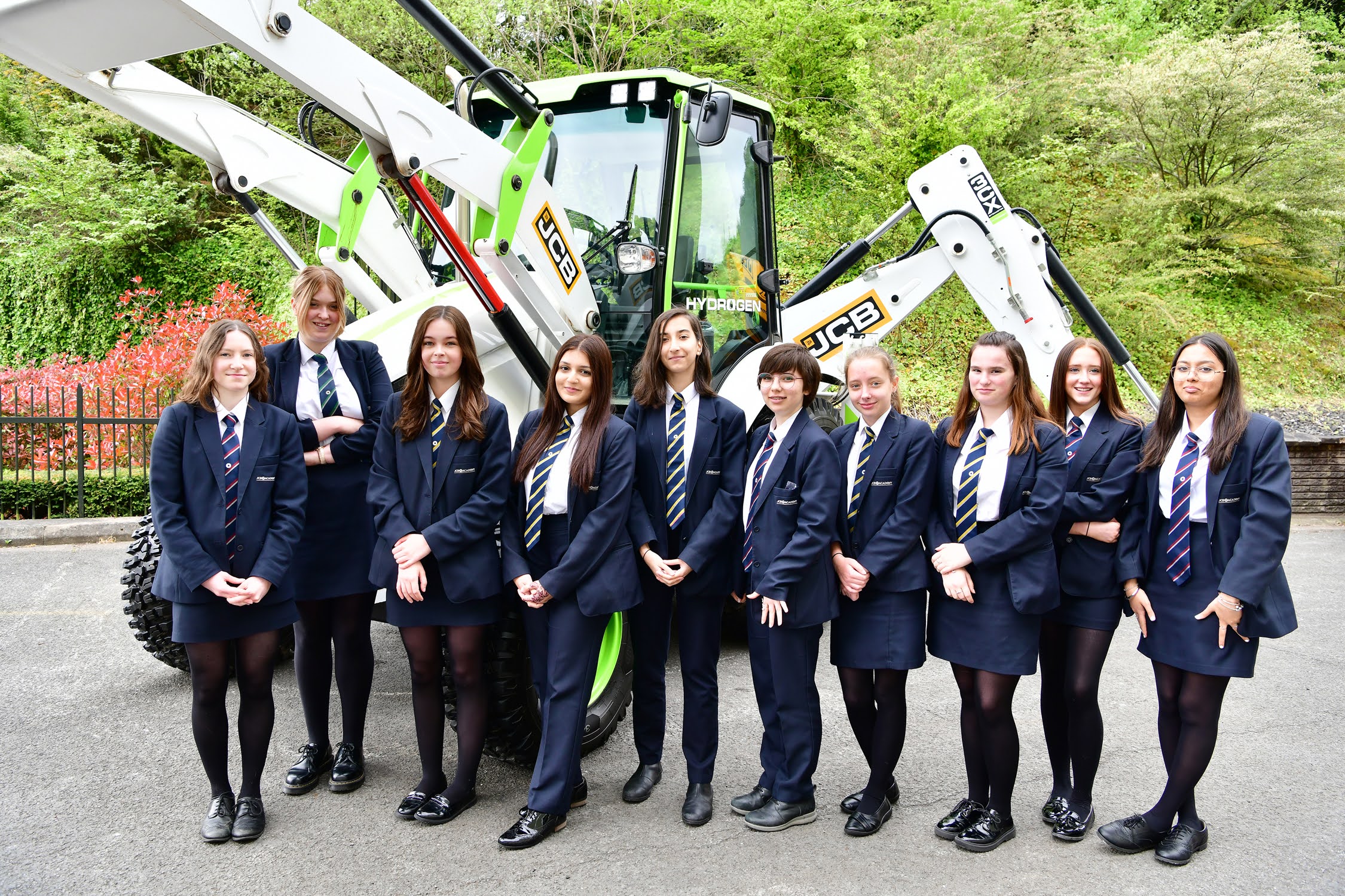 Students standing in front of a digger.