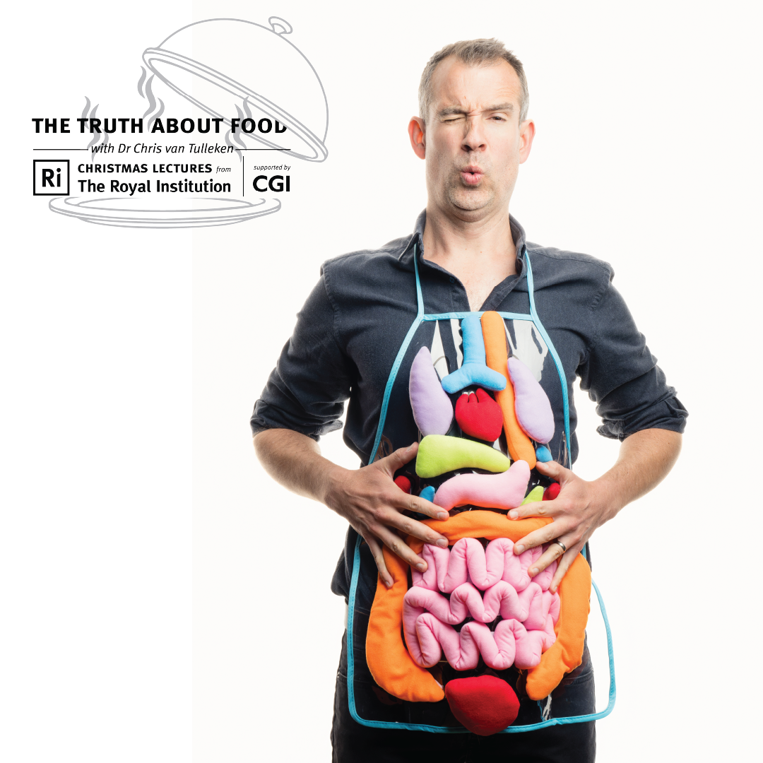 An image of Chris van Tulleken wearing an apron that shows all the organs of the human body. He is holding his tummy and pretending to be in discomfort.