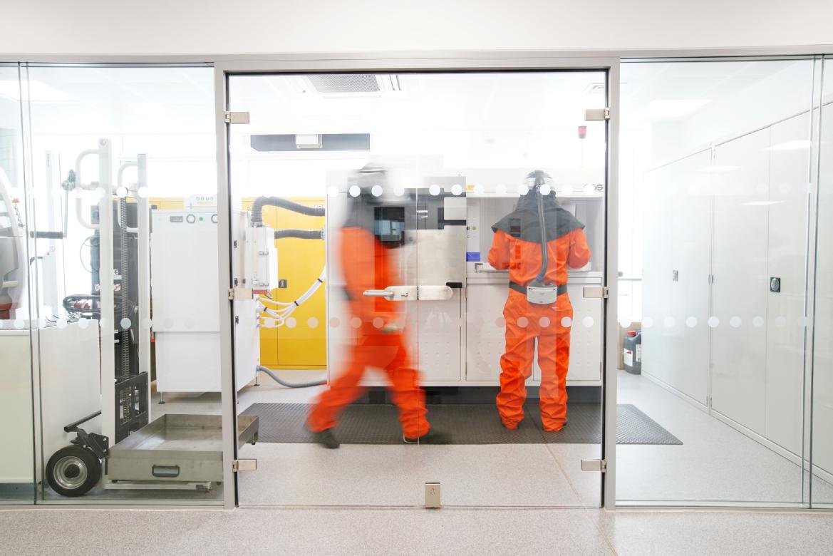 two people in protective suits using equipment