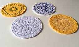 4 yellow and white felt coasters with patterns stitched on them