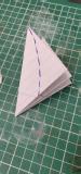 The pentagon of paper has been folded up and a shape drawn on it to cut out to make petals