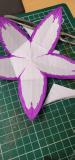 Paper flower with petals coloured in with purple pen
