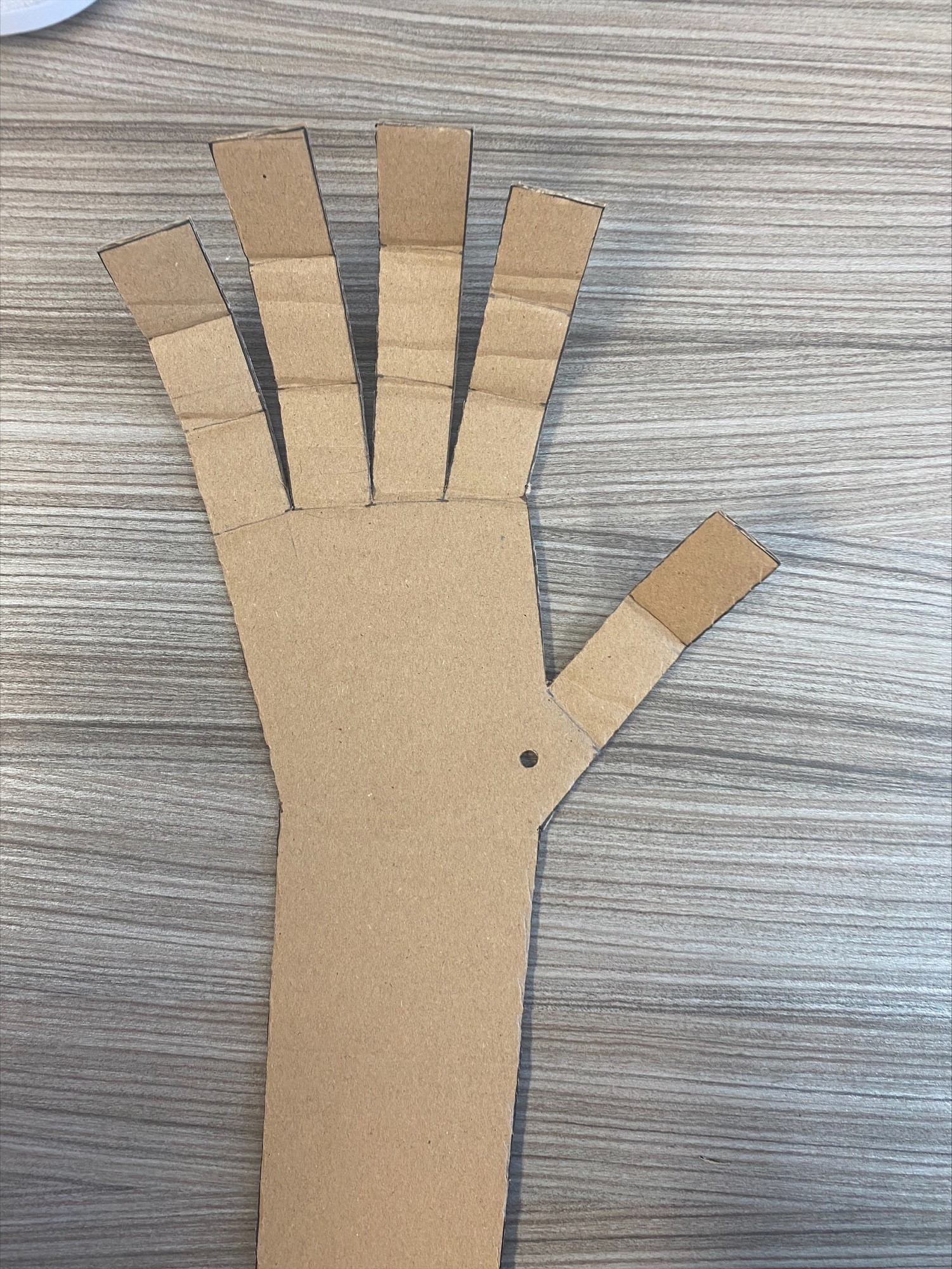 A small hole is made right under the cardboard thumb 