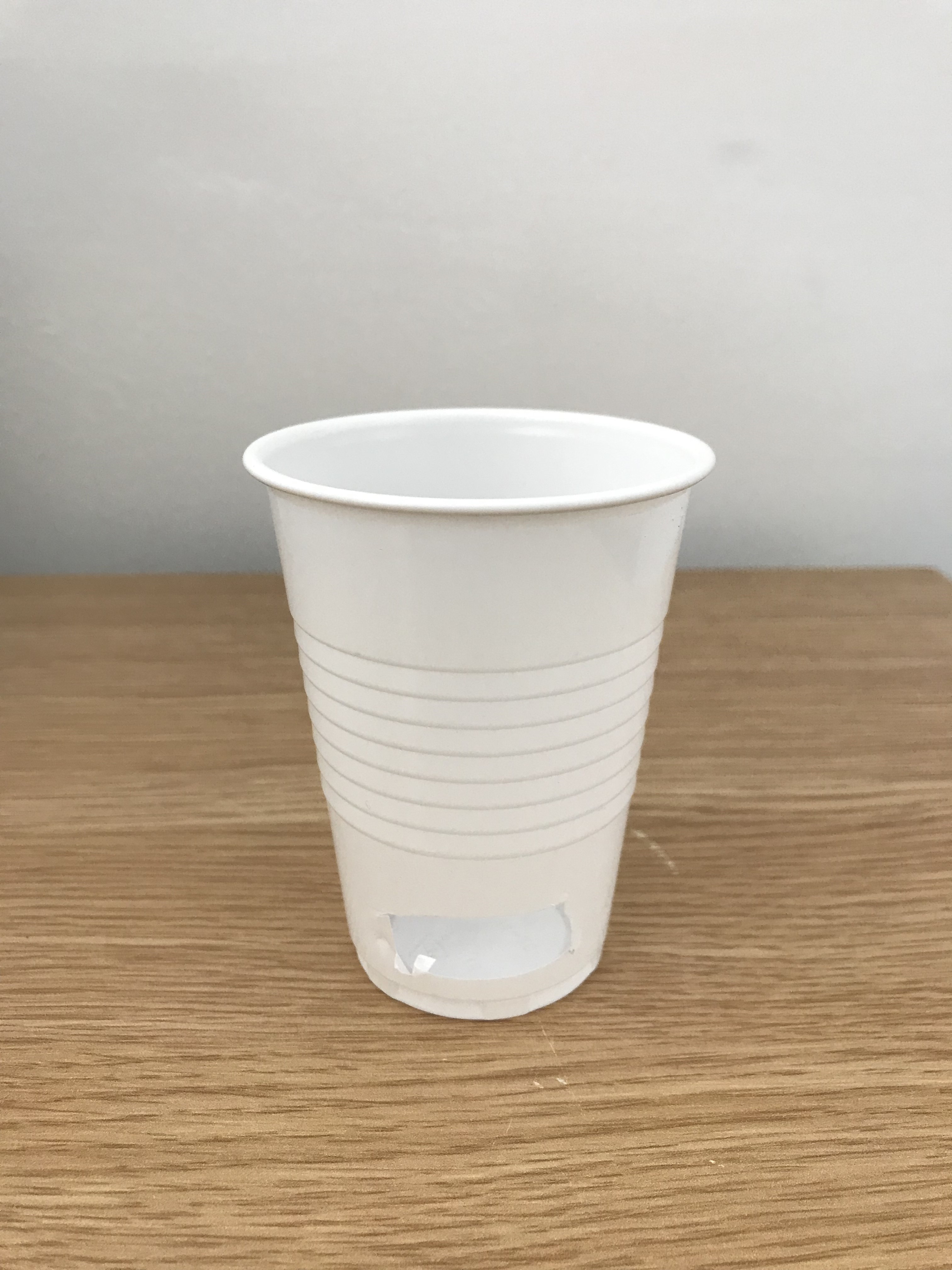 A plastic cup with part of the bottom removed
